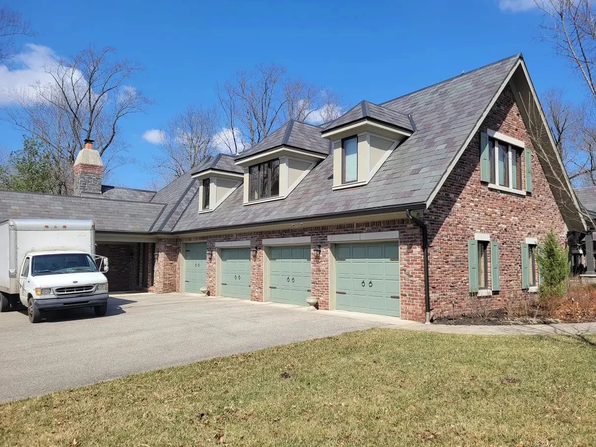 Finished brick home with seamless white gutters and downspouts